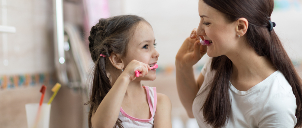 mother and daughter brushing teeth